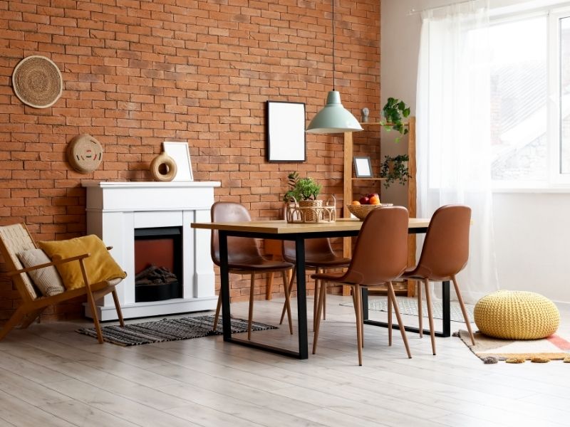 Brick fireplace with a decorative brick surround, wooden mantel, and built-in breakfast nook seating in McKinney, Texas.
