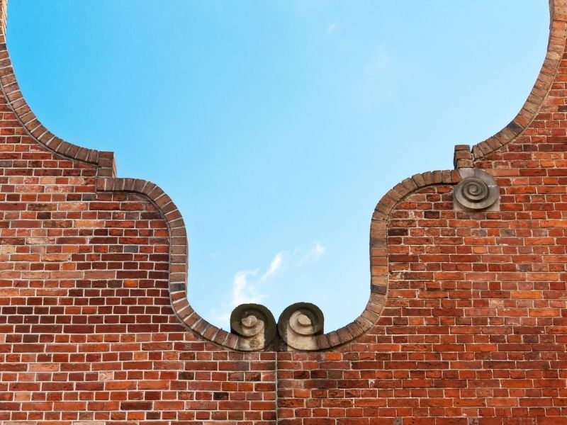  Decorative brick gable end bands on a McKinney, Texas, home, featuring contrasting brick patterns, clean sloped roofline cuts, and detailed mortar joints.

