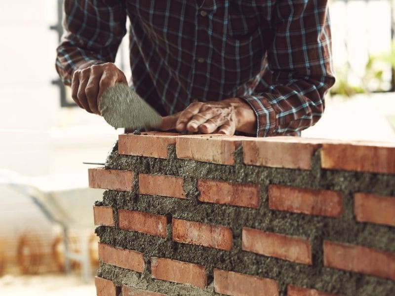 Masonry inspection of brick and stone features showing cracks, mortar joints, pavers, drainage, and surface damage
